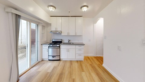 a kitchen with white cabinets and a sliding glass door